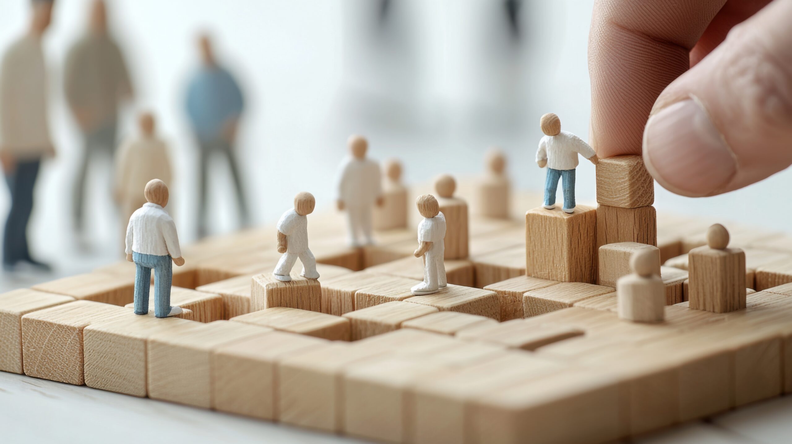 Explore a conceptual HR model featuring miniature wooden figures engaging in a collaborative environment. Ideal for illustrating teamwork and strategy in business contexts.